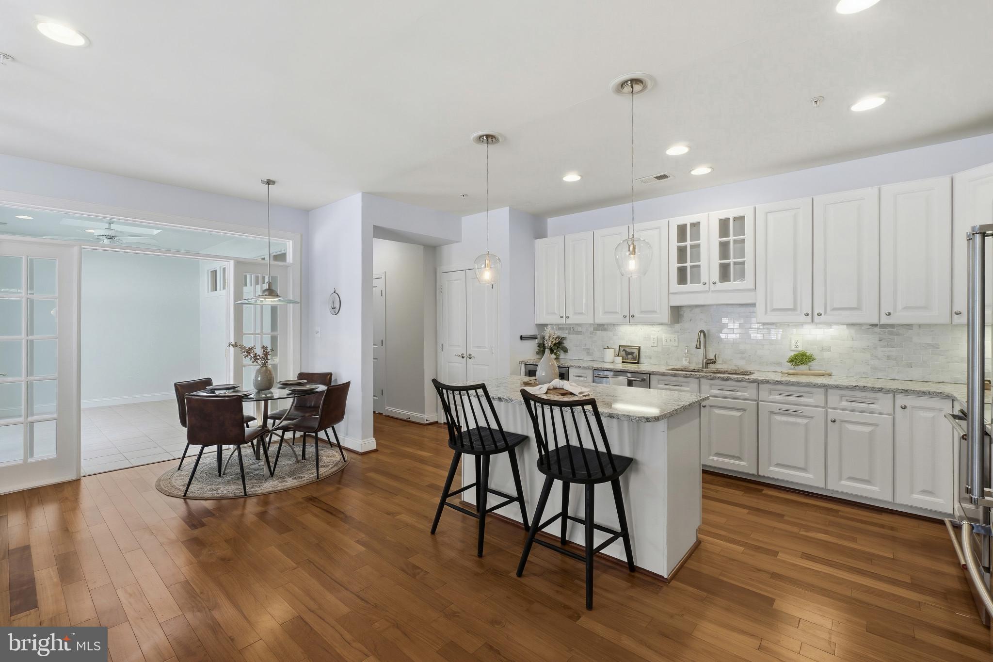 2607 Buckingham Road, Unit 78 Ellicott City, MD 21043 - Photo 10 of 43 a kitchen with stainless steel appliances granite countertop a dining table chairs microwave and sink