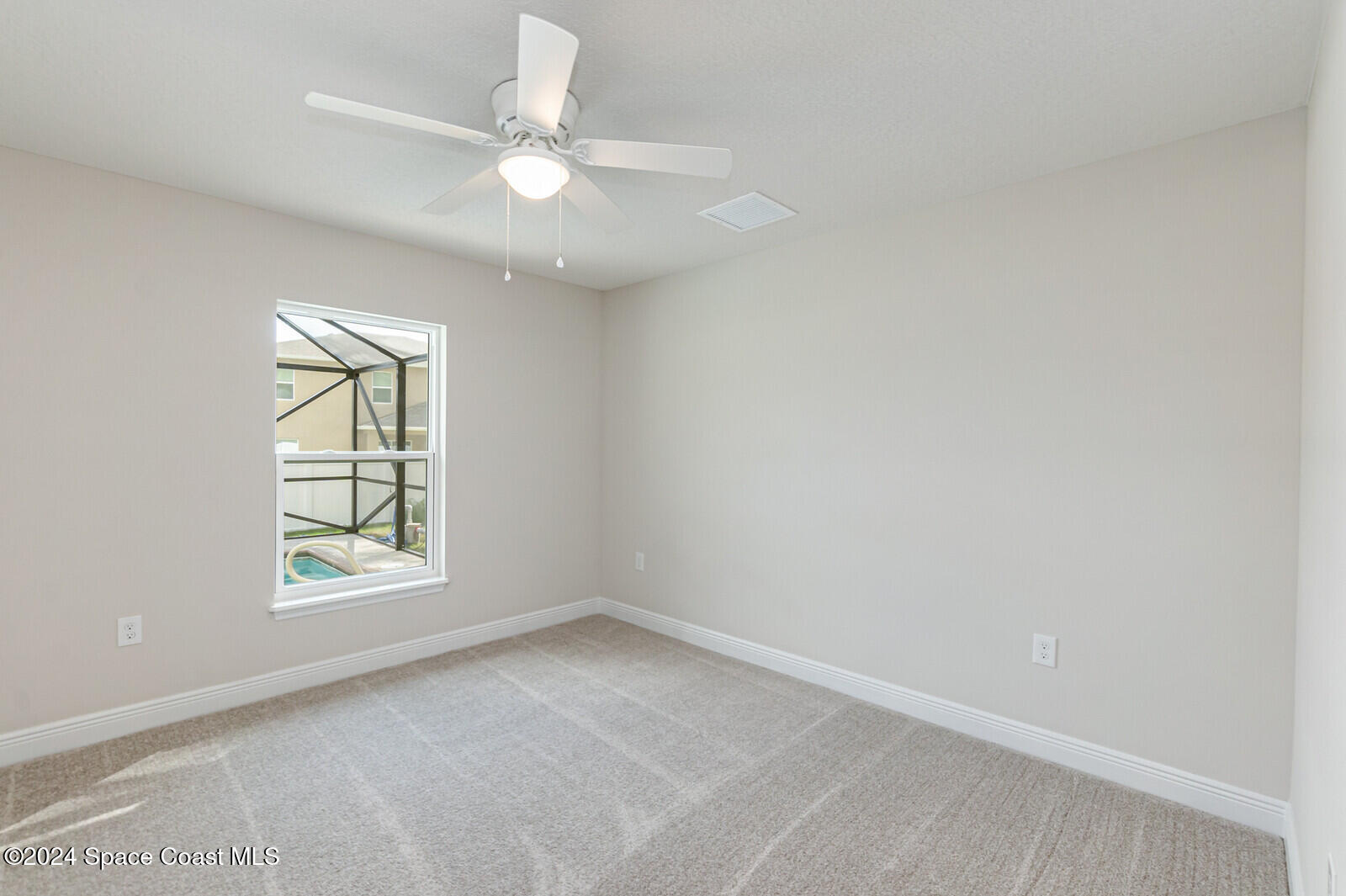 347 Trilby Road Southwest Palm Bay, FL 32908 - Photo 6 of 9 an empty room with window and ceiling fan
