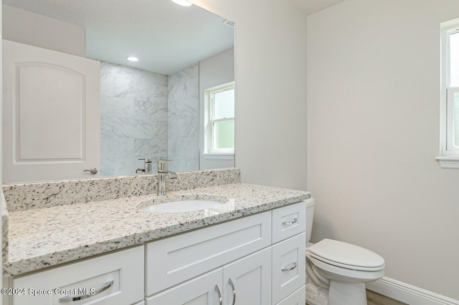 347 Trilby Road Southwest Palm Bay, FL 32908 - Photo 7 of 9 a bathroom with a granite countertop sink a toilet and a mirror