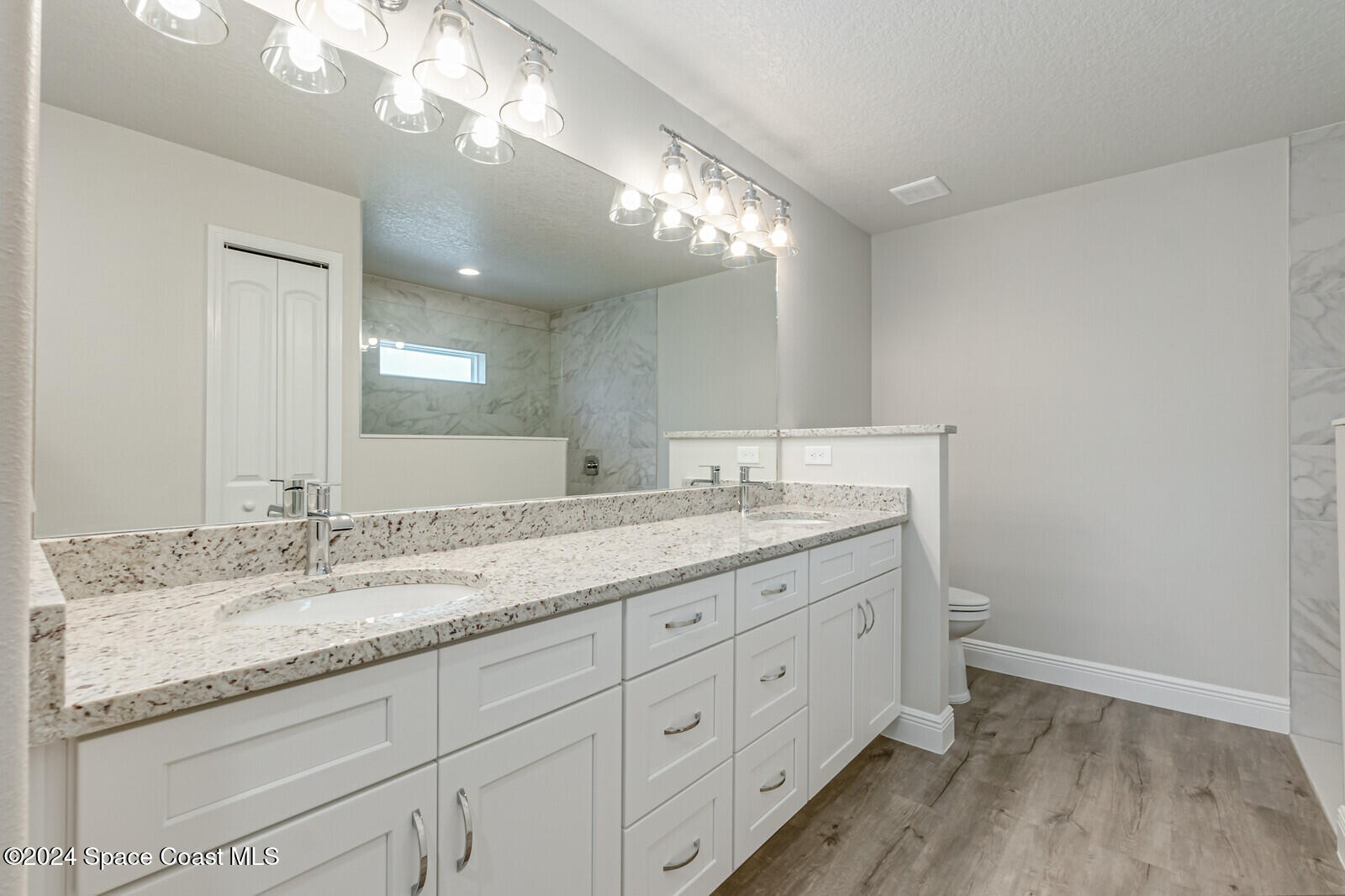 347 Trilby Road Southwest Palm Bay, FL 32908 - Photo 8 of 9 a bathroom with a granite countertop sink a large mirror and vanity