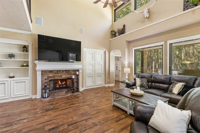 a living room with furniture a fireplace and a flat screen tv