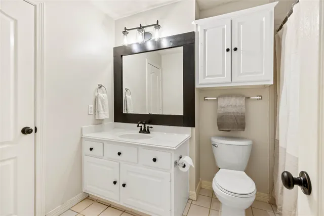 a bathroom with a toilet sink vanity and mirror