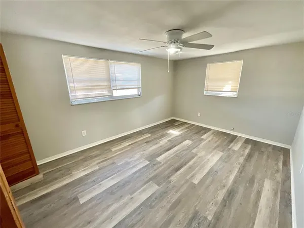 a view of a room that has a window and wooden floor