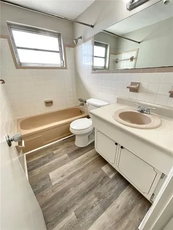 a bathroom with a double vanity sink toilet mirror and bathtub