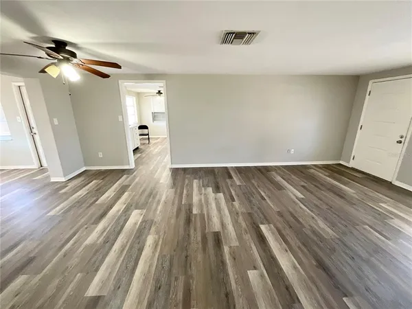 a view of empty room with wooden floor