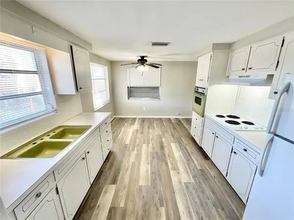 a spacious bathroom with a granite countertop sink a large mirror and a bathtub