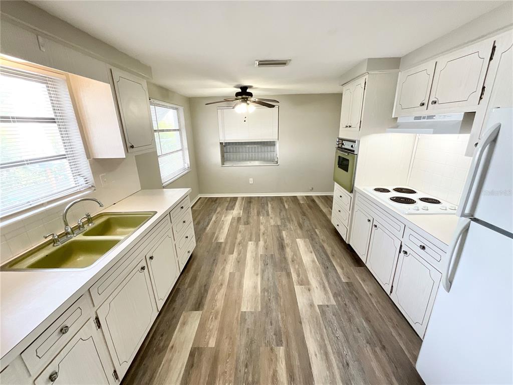 1541 Alert Street Holiday, FL 34690 - Photo 4 of 17 a kitchen with a sink a stove a refrigerator and cabinets
