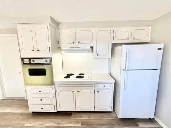a kitchen with cabinets a refrigerator and a stove