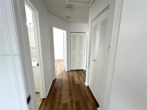 a view of a hallway with wooden floor