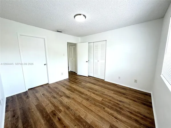 a view of empty room with wooden floor