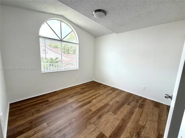an empty room with wooden floor windows and a wooden floor