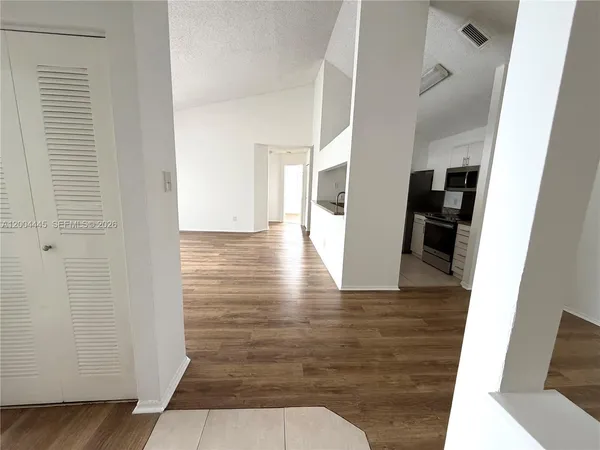 a view of a hallway with wooden floor and staircase