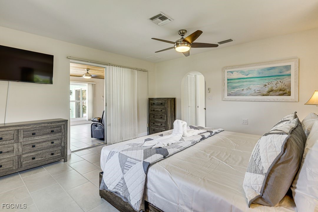 15340 River By Road Fort Myers, FL 33908 - Photo 13 of 21 a bedroom with a bed a mirror on dresser and a flat screen tv