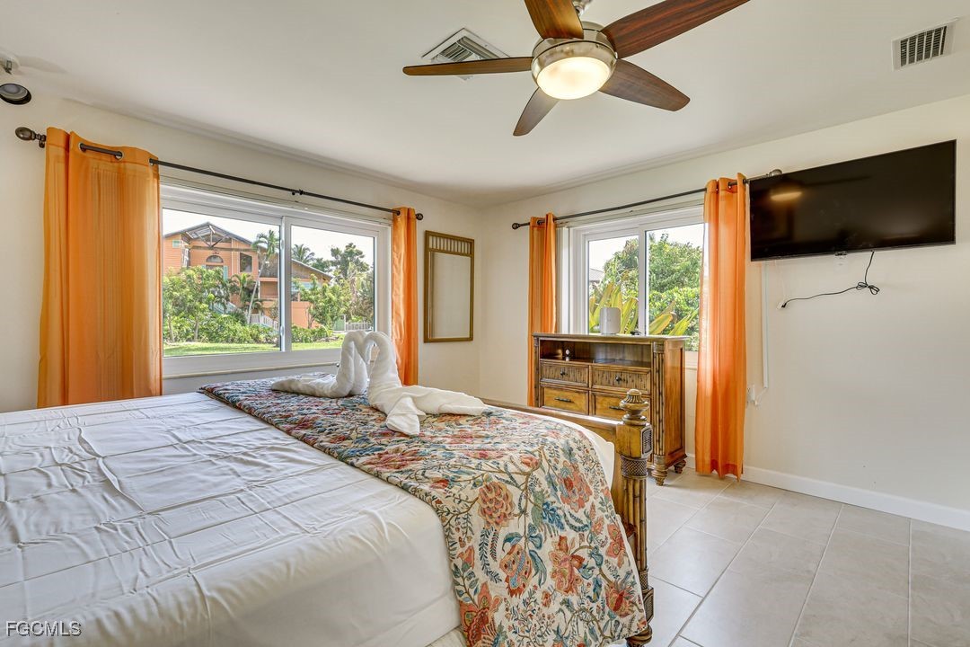 15340 River By Road Fort Myers, FL 33908 - Photo 10 of 21 a bedroom with a large bed and a flat tv screen on dresser