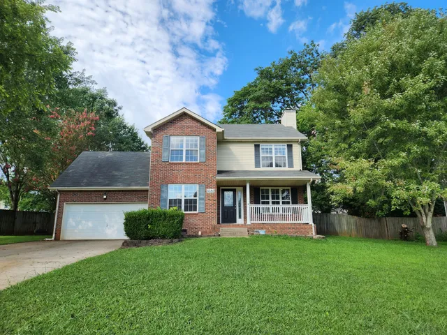 a front view of a house with yard and green space