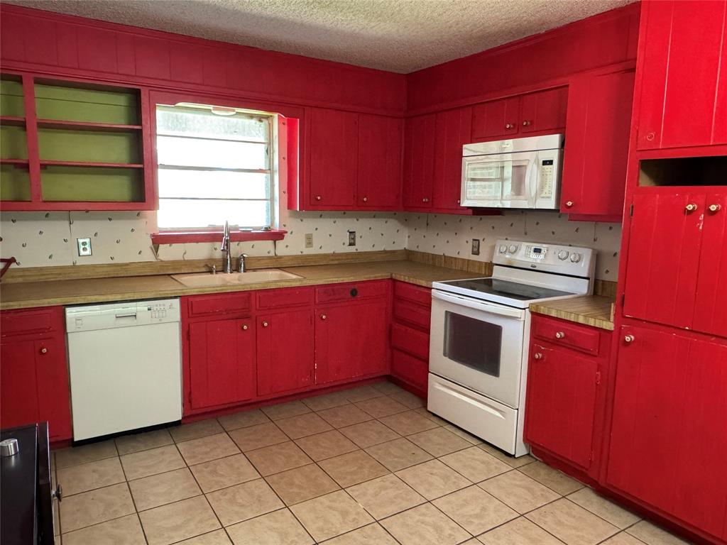 415 Meadowlark Trail Springtown, TX 76082 - Photo 6 of 40 a kitchen with a stove sink and cabinets