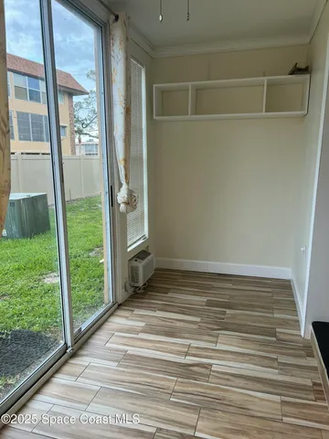 a view of a small space with wooden floor and a window
