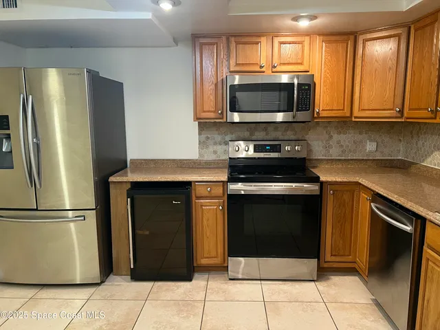 a kitchen with stainless steel appliances granite countertop a refrigerator stove and microwave