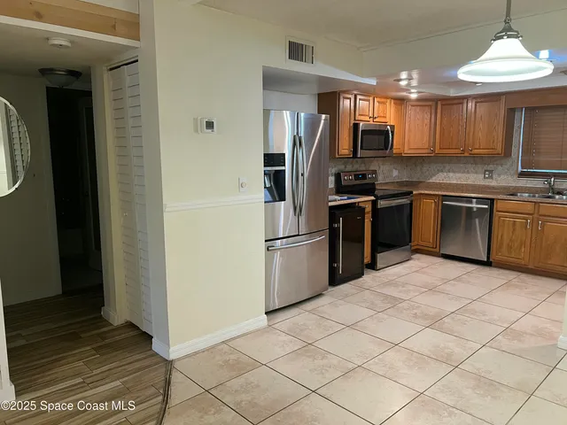 a kitchen with granite countertop a refrigerator and a stove top oven