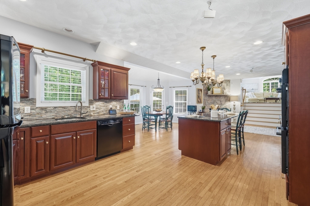 25 Haymeadow Road Boxford, MA 01921 - Photo 13 of 42 a kitchen with stainless steel appliances granite countertop wooden floors and wooden cabinets