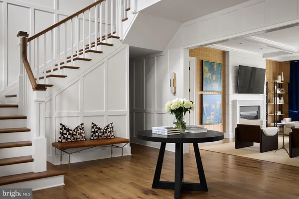 a living room with furniture stairs and a potted plant