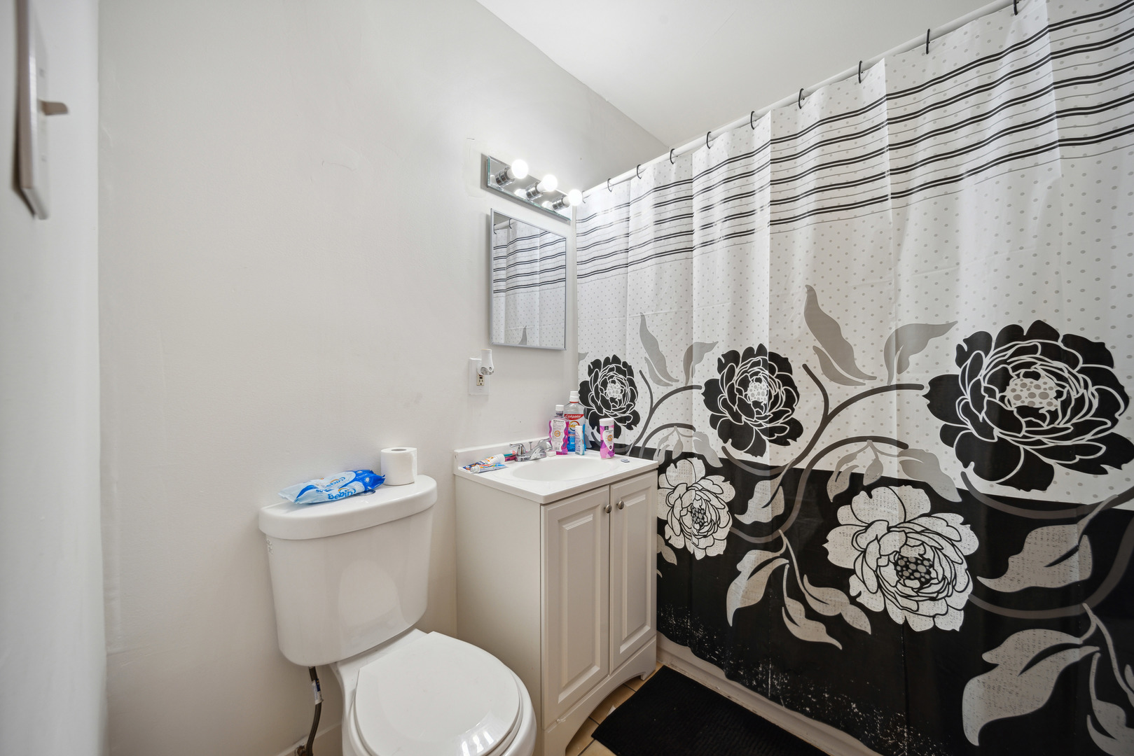 1453 South Springfield Avenue Chicago, IL 60623 - Photo 6 of 13 a white toilet sitting next to a white curtain and sink