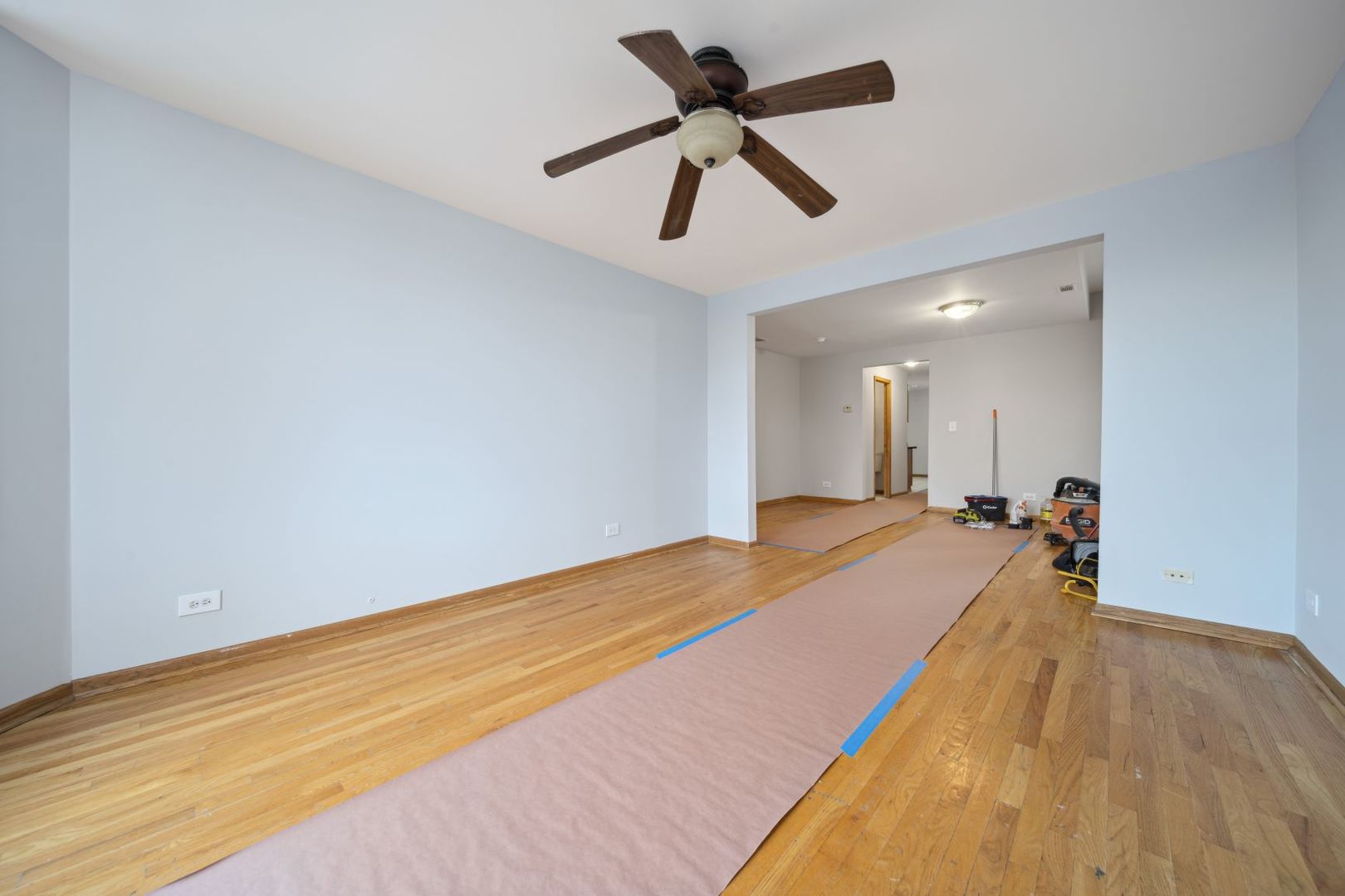 1453 South Springfield Avenue Chicago, IL 60623 - Photo 8 of 13 a view of a room with wooden floor and a ceiling fan