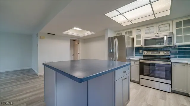 a kitchen with stainless steel appliances kitchen island granite countertop a stove a sink and a refrigerator
