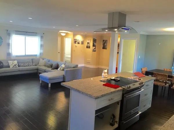 a kitchen with a stove and a living room