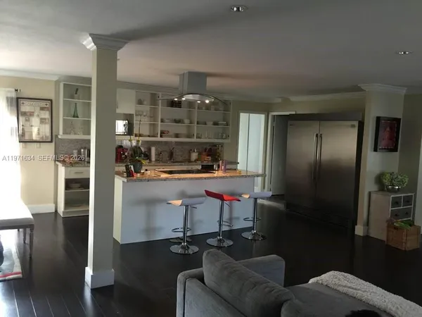 a kitchen with stainless steel appliances kitchen island granite countertop a refrigerator and a stove top oven