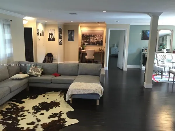 a living room with furniture and wooden floor