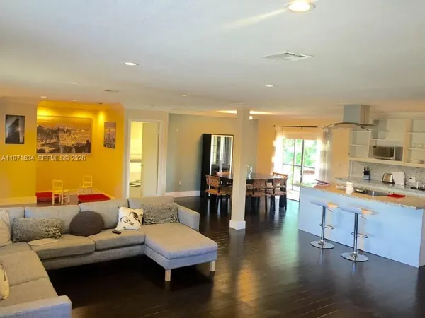 a living room with furniture and wooden floor