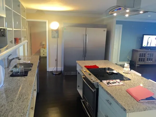 a kitchen that has a stove and a wooden floor