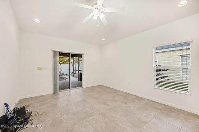 an empty room with windows and fan
