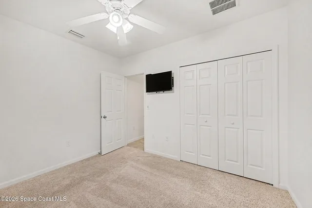 an empty room with fan and windows