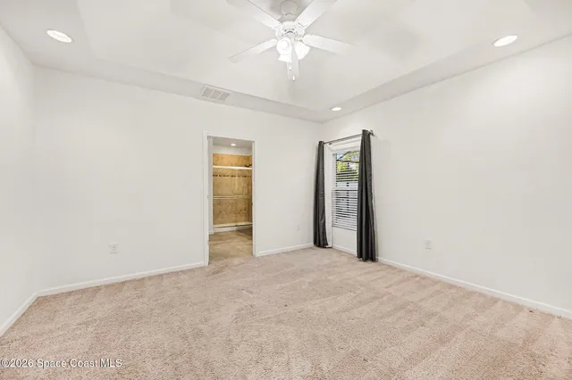 an empty room with closet and a ceiling fan