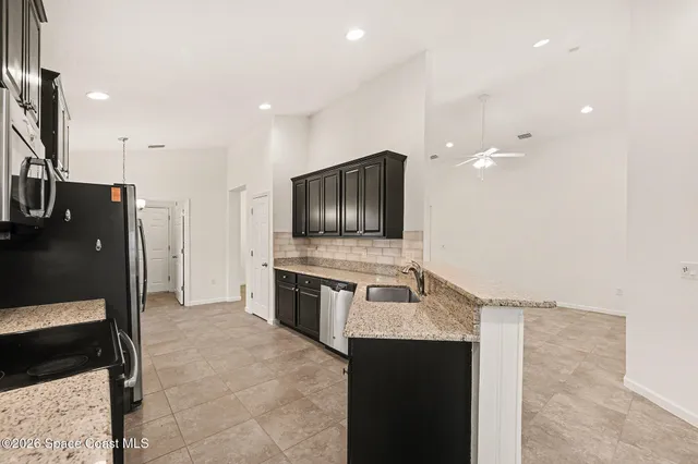 a kitchen with stainless steel appliances kitchen island granite countertop a refrigerator and a stove top oven