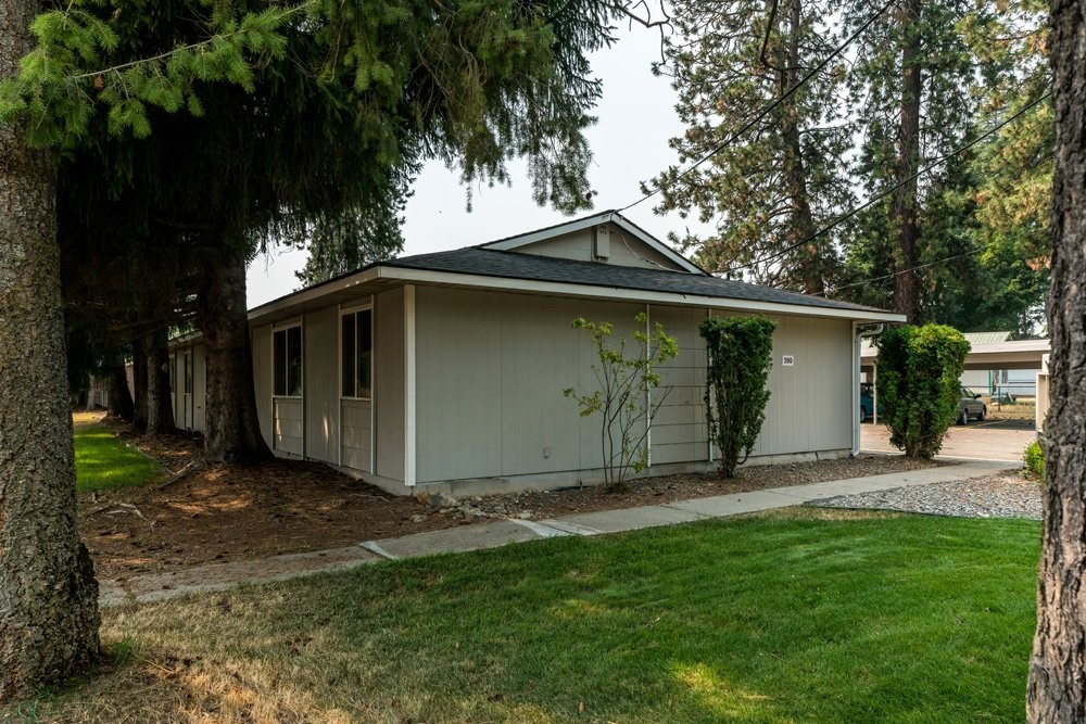 303 Harriet Street Priest River, ID 83856 - Photo 1 of 9 a view of backyard with large trees and a barn
