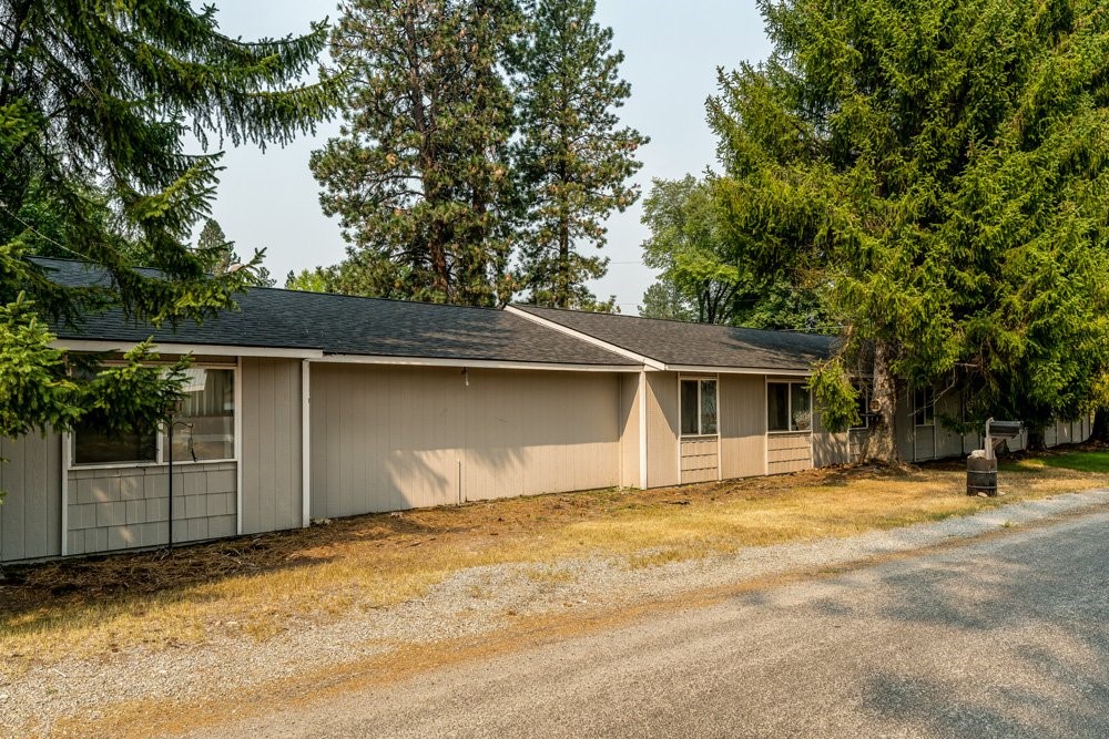 303 Harriet Street Priest River, ID 83856 - Photo 6 of 9 a house with trees in the background