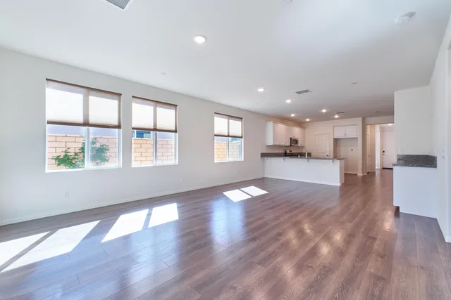 a kitchen with wooden floors white cabinets appliances and sink
