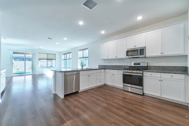 a kitchen with white cabinets stainless steel appliances and sink