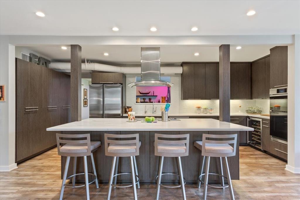 1617 Rambler Drive Waco, TX 76710 - Photo 14 of 36 Kitchen featuring a kitchen breakfast bar, island exhaust hood, freestanding refrigerator, light wood-style flooring, and recessed lighting