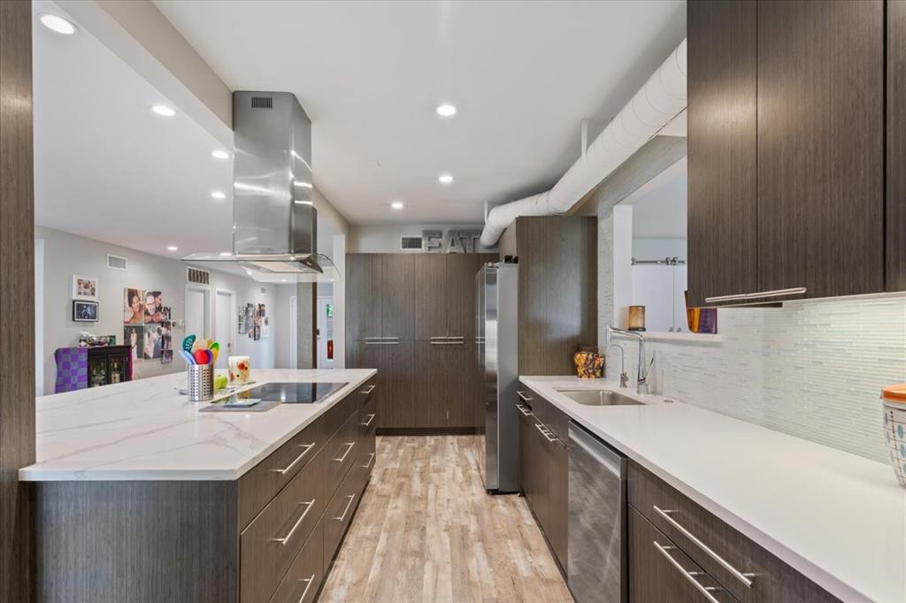 1617 Rambler Drive Waco, TX 76710 - Photo 15 of 36 Kitchen with dark wood finish cabinetry, light wood-style flooring, stainless steel appliances, modern cabinets, and recessed lighting