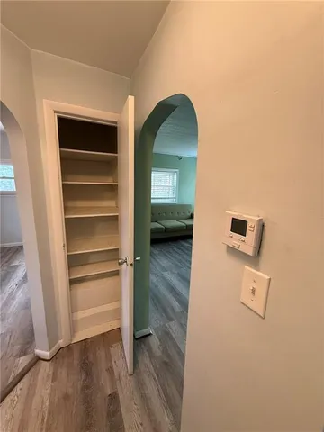a view of a hallway with wooden floor and a cabinet