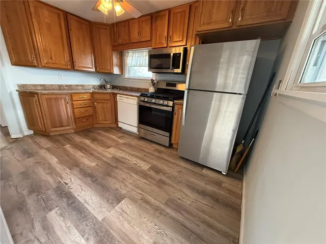 a kitchen with granite countertop stainless steel appliances a refrigerator a stove a sink and cabinets