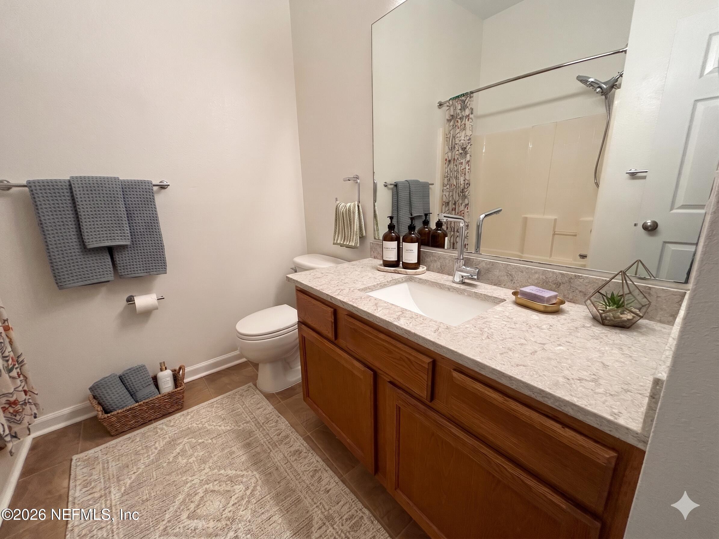 9627 Belda Way, Unit 8 Jacksonville, FL 32257 - Photo 17 of 27 a bathroom with a granite countertop sink a toilet and a mirror