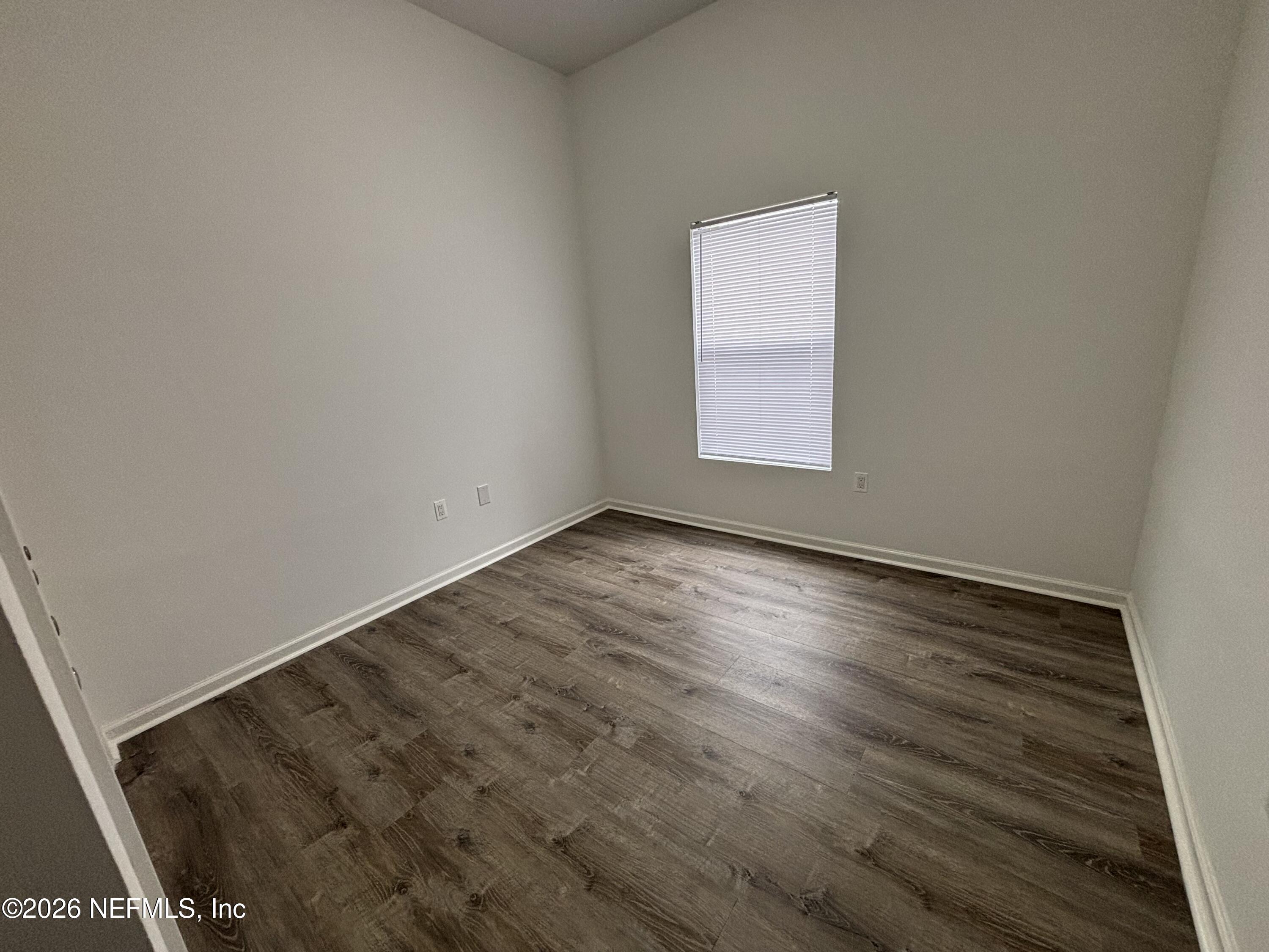 9627 Belda Way, Unit 8 Jacksonville, FL 32257 - Photo 21 of 27 an empty room with wooden floor and windows
