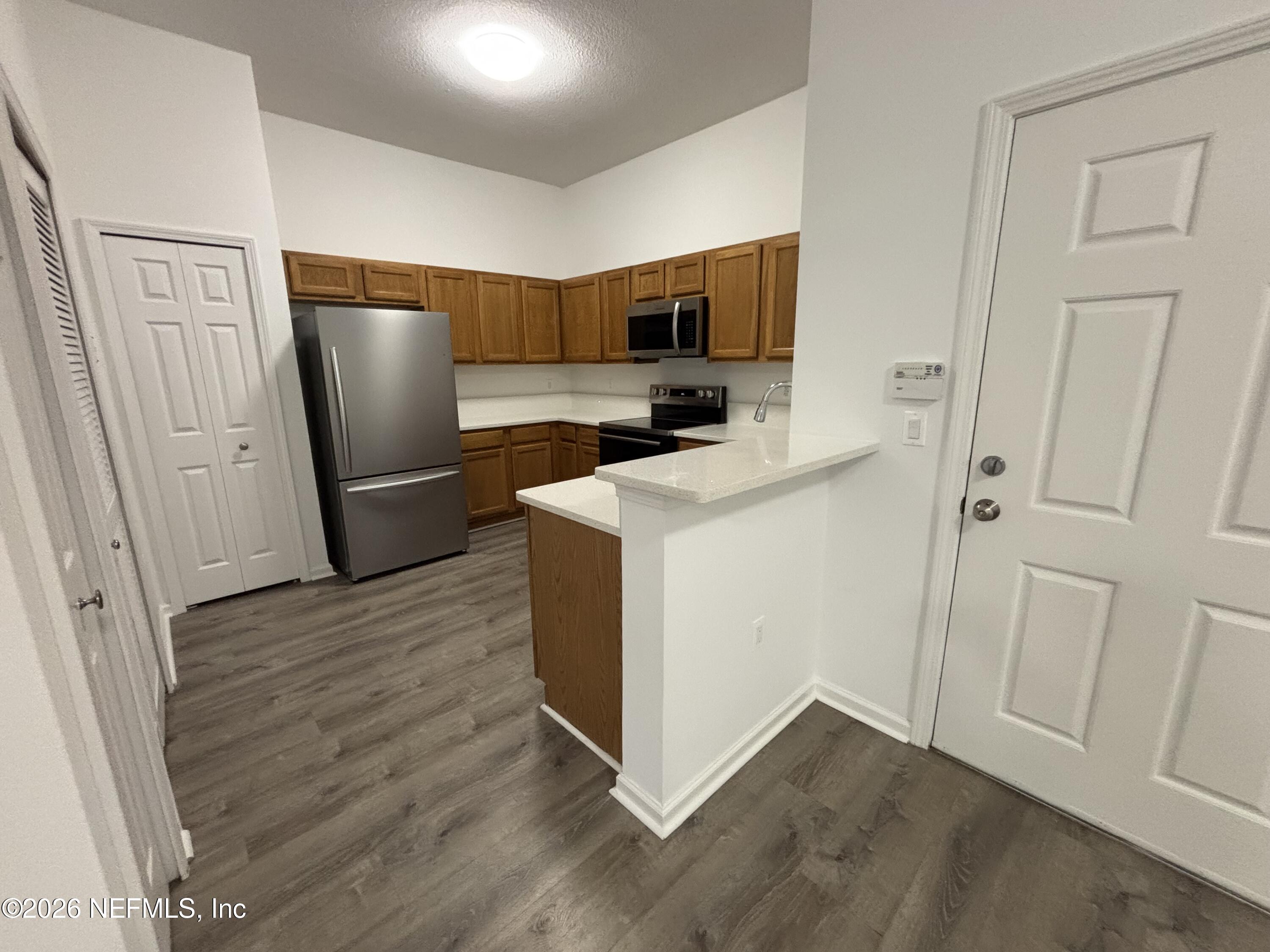 9627 Belda Way, Unit 8 Jacksonville, FL 32257 - Photo 4 of 27 a view of a kitchen with refrigerator and wooden floor