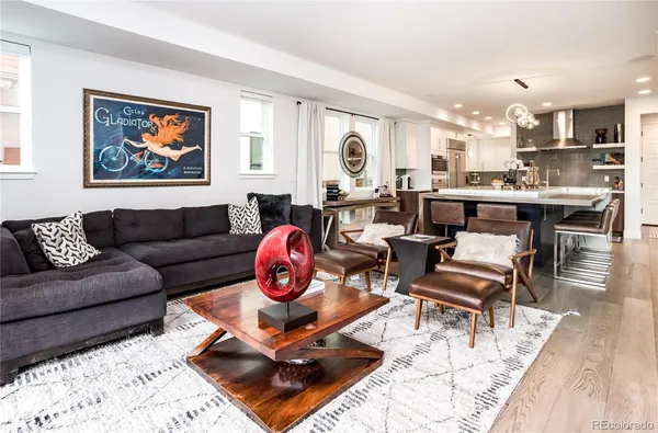 a living room with furniture a rug and kitchen view