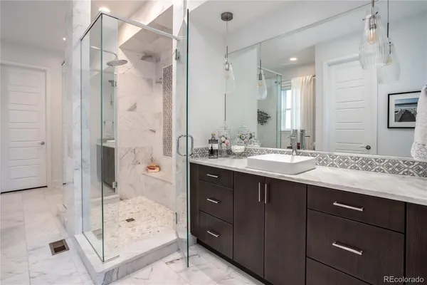 a bathroom with a granite countertop sink mirror and shower